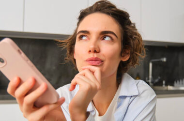 femme se posant des questions devant son smartphone